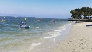 A beach with kayaks and a few people paddling. - Spacious Condo in the heart of Harbor Town! (Hilton Head Island, USA)