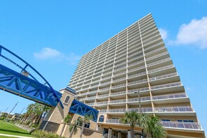 Ein hohes Hotel mit zahlreichen Balkonen und einer blauen Brückenkonstruktion im Vordergrund.