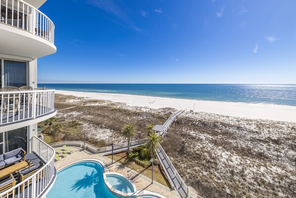 A beachfront hotel with a pool, a beach view, and a boardwalk. - Spanish Key 507 | Steps from Flora Bama | Oceanfront Condo | Pools, Hot Tub, Gym & More! (Pensacola)