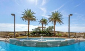 Relax by the pool surrounded by palm trees and a gazebo.