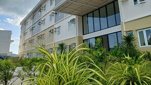 Un immeuble à plusieurs étages, doté d’un toit plat, de grandes fenêtres et de climatiseurs.