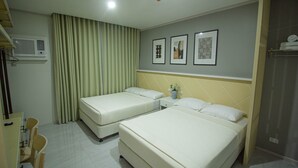 Une chambre d’hôtel avec deux lits, un bureau, des chaises et une fenêtre avec des rideaux.
