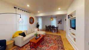 Un salon moderne avec un canapé, une table basse et un coin repas.