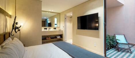 Quarto moderno com uma cama grande, televisão na parede e varanda com piso xadrez.