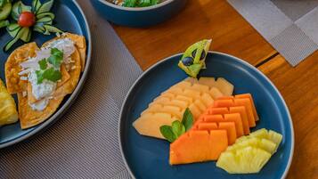 Uma mesa de café da manhã com diversos pratos, incluindo ovos, torradas com abacate e frutas.