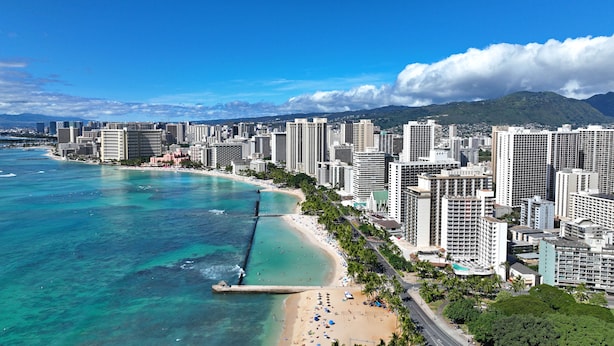 A coastal cityscape with high-rise buildings, a beach, and a clear blue sky. - Scandia 203 - Sleeps 6, Full Kitchen, Free Parking, and 1 Block to the Beach (Honolulu)