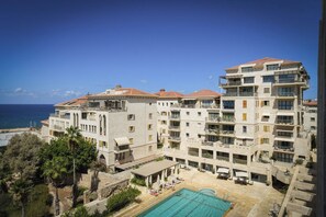 A multi-story hotel with a pool area and balconies.