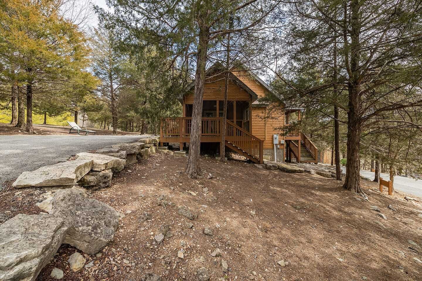 Une cabane avec une façade en bois, une véranda et un escalier menant à l’entrée.
