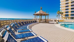 A poolside area with lounge chairs and a gazebo. - Summer House 705B | Gorgeous Beach Front, Huge Deck, Great Location (Orange Beach)