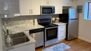Una cocina moderna con gabinetes blancos, electrodomésticos de acero inoxidable y un salpicadero decorado.