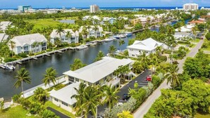 A coastal residential area with houses, a marina, and a clear view of the ocean.