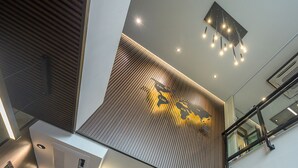 A modern interior with a sloped ceiling, recessed lighting, and a decorative wall with a world map design. - Le Bis Hotel  (Chiang Mai)