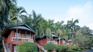 A row of red brick houses with white railings, surrounded by lush greenery and palm trees. - Zone Niathu Dimapur By The Park (Dimapur)