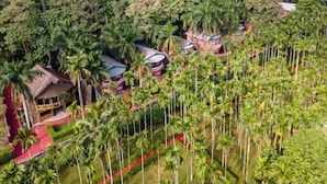 A resort with multiple buildings surrounded by palm trees and lush greenery. - Zone Niathu Dimapur By The Park (Dimapur)