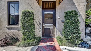 Un edificio con una porta nera che reca la scritta "The Parker's", una finestra e un vialetto in mattoni che conduce all'ingresso.
