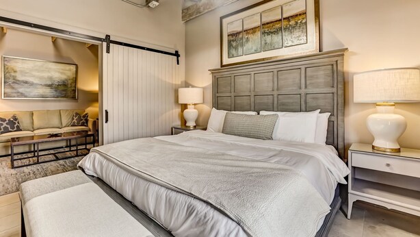 Un'ampia camera da letto con un letto grande, una poltrona e una porta scorrevole.