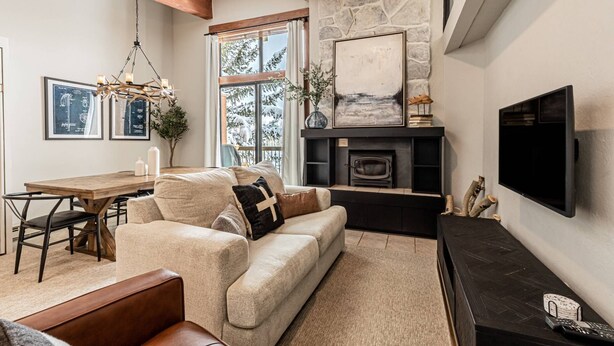 A cozy living room with a fireplace, a television, and a dining area with a table and chairs.