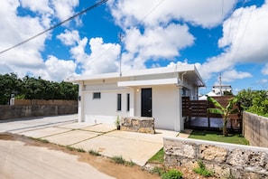 Stylish single-story home with a minimalist design, featuring a paved driveway, garden, and entrance.