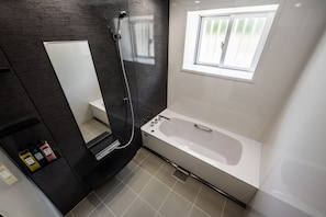 Enjoy a relaxing soak in the bathtub or refreshing shower, with ample space for grooming in front of the large mirror.