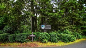 Un letrero del Parque Estatal Umpqua Lighthouse, con un aviso de 'VACANCY' cerca.