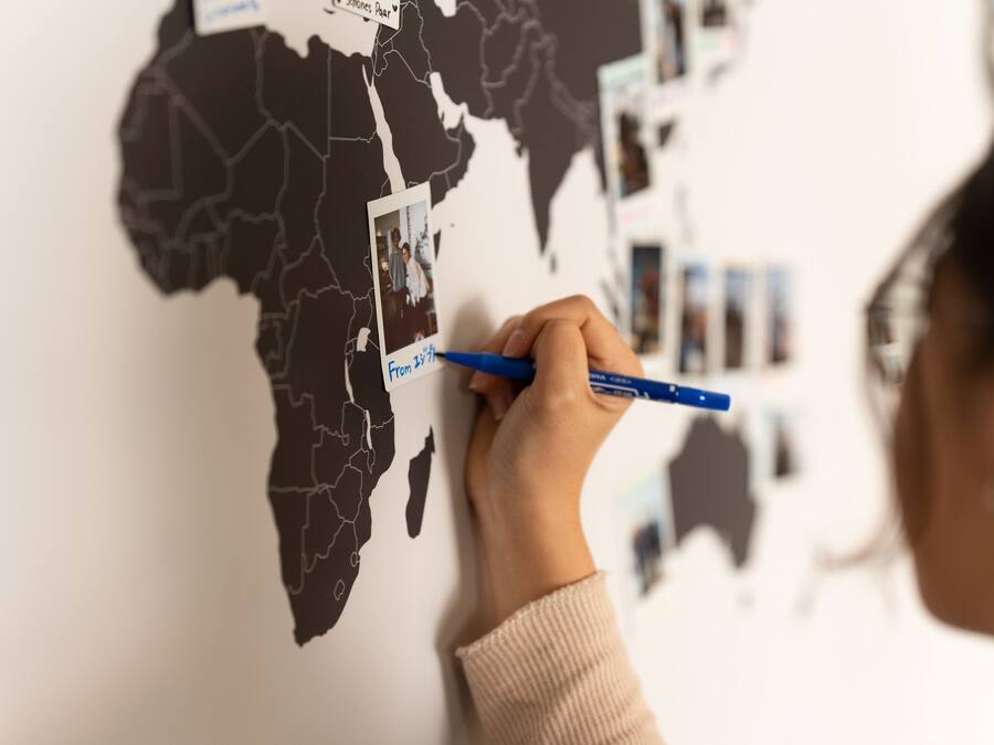 A person marking a map with a blue pen.