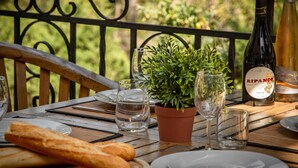 Ein Holztisch mit einem Topfpflanzen, Weinflaschen, Gläsern und Brot.
