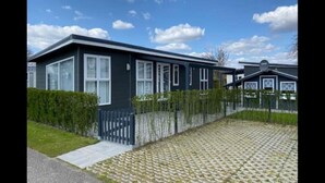 En moderne vogn med belagt indkørsel og hegnede have.