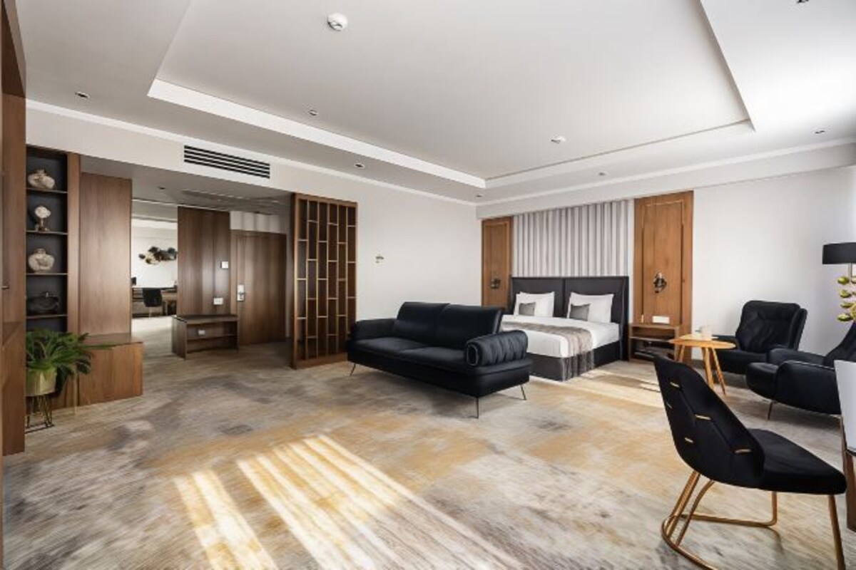 Une chambre d’hôtel moderne équipée d’un lit, d’un canapé, d’un bureau et d’une chaise.