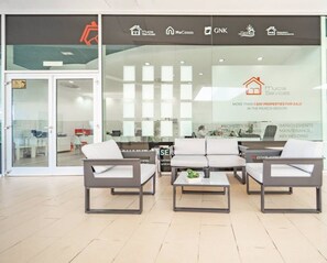 A modern office space with a reception area featuring a sofa set and a coffee table. - A bright pool views apartment - CO1011LT (Torre-Pacheco)