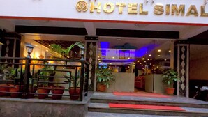 The entrance of Hotel Simal with steps leading up to the entrance, potted plants, and a red carpet. - Hotel Simal (Kathmandu)