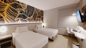 A hotel room with two beds, a desk, a chair, a TV, and a decorative wall panel.