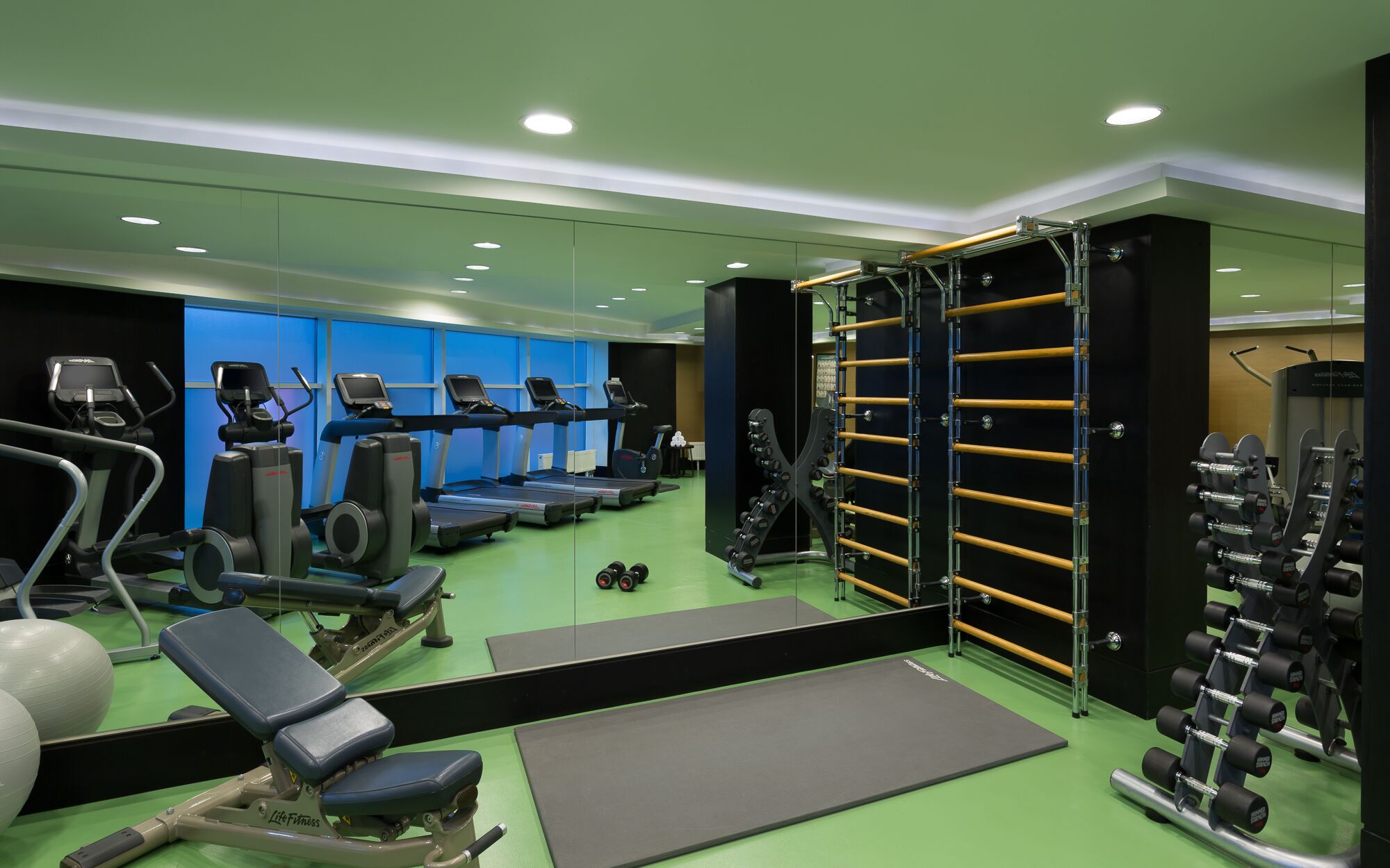 A gym with treadmills, weight machines, and a squat rack.