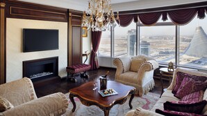 Un salón lujoso con un televisor grande, una chimenea y vistas a un paisaje urbano.