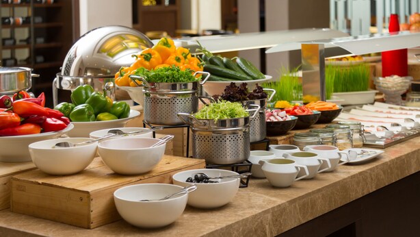 Una mesa de buffet con diversos alimentos y utensilios.