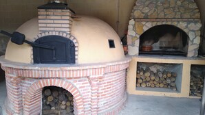 Un horno de ladrillo con chimenea de piedra y un horno separado de leña.