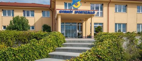 A building with a sign reading 'GYIRMOT SPORTSZÁLLÓ' and a logo above it.