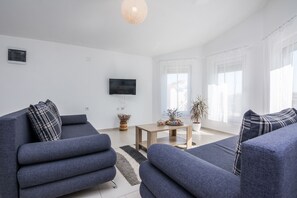 Family Apartment (A1) | Wohnbereich | 100-cm-Flachbildfernseher mit Satellitenempfang, Fernseher