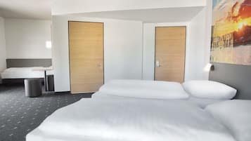 Ein Hotelzimmer mit einem großen Bett, zwei Türen, einer Bank und einer Wandlampe.