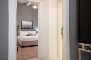 Una camera da letto con un letto, un quadro appeso al muro e un televisore su un mobile.
