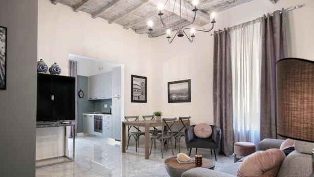 Una sala de estar moderna con un sofá, una mesa de centro y un comedor con una mesa y sillas.