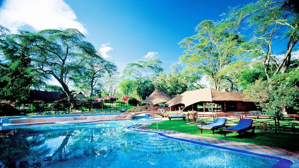 A swimming pool with blue water, surrounded by trees and lounge chairs. - Lake Naivasha Sopa Resort (Naivasha)
