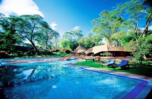 A swimming pool with blue water, surrounded by trees and lounge chairs. - Lake Naivasha Sopa Resort (Naivasha)