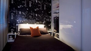 A bedroom with a bed, a nightstand, a wardrobe, and a cityscape wallpaper. - Luxury apartment in Ponte Vecchio (Firenze)