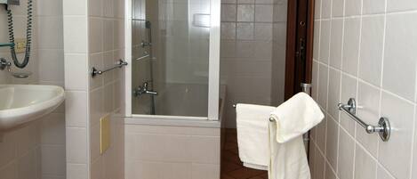 Un baño con lavamanos, ducha y bañera.