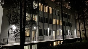 A multi-story building with illuminated windows and a balcony. - DORM BG (Stara Zagora)