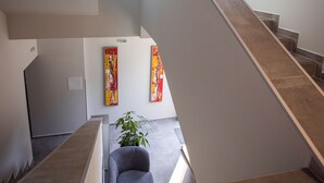 A modern interior with a staircase, artwork on the walls, and a plant. - DORM BG (Stara Zagora)