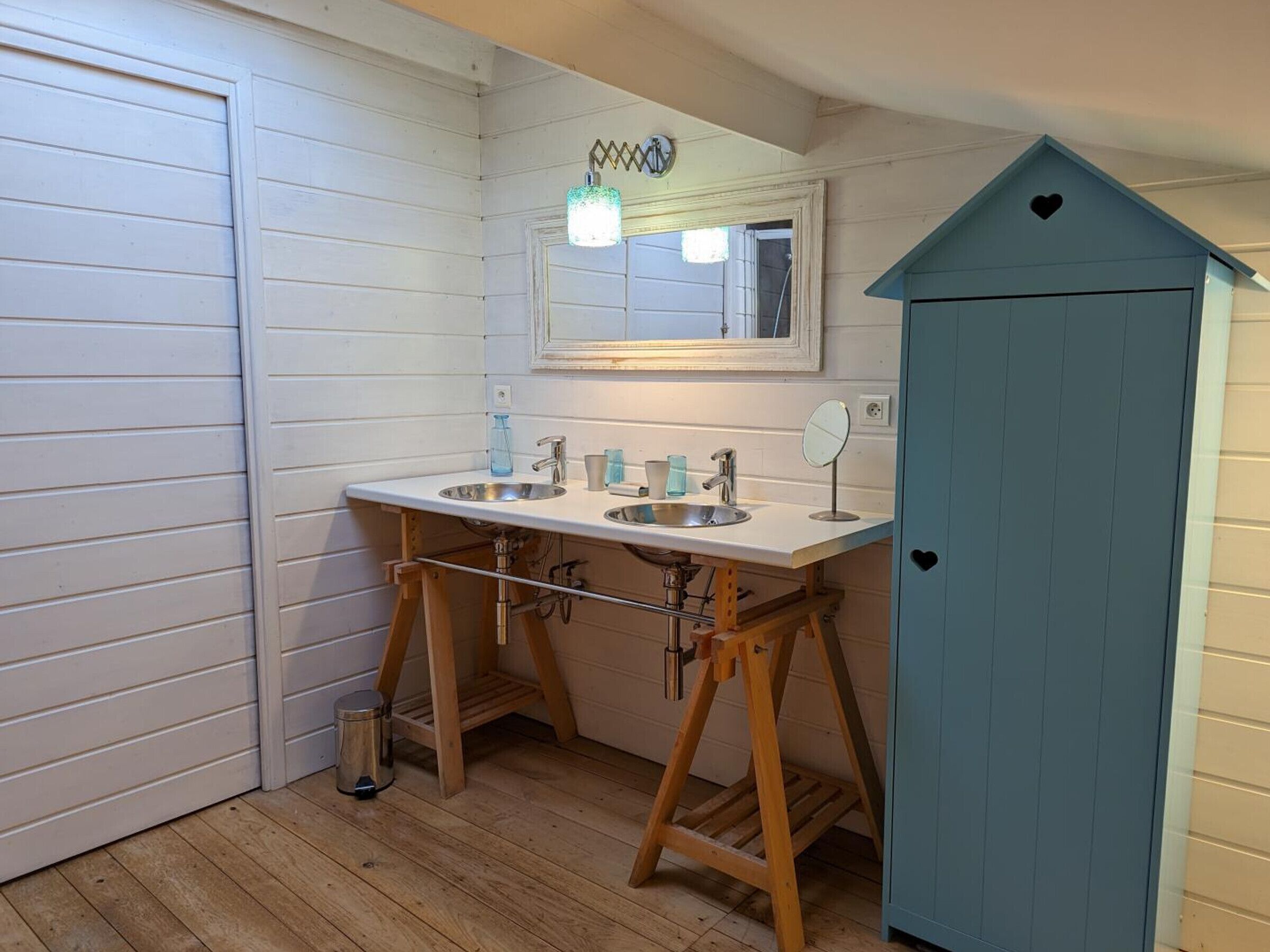 A bathroom with two sinks, a mirror, and a blue cabinet.