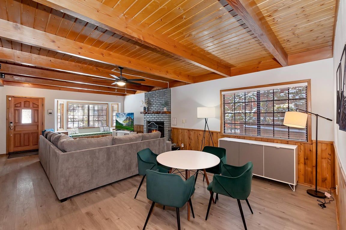 A cozy living area with a sofa, chairs, a round table, and a fireplace.