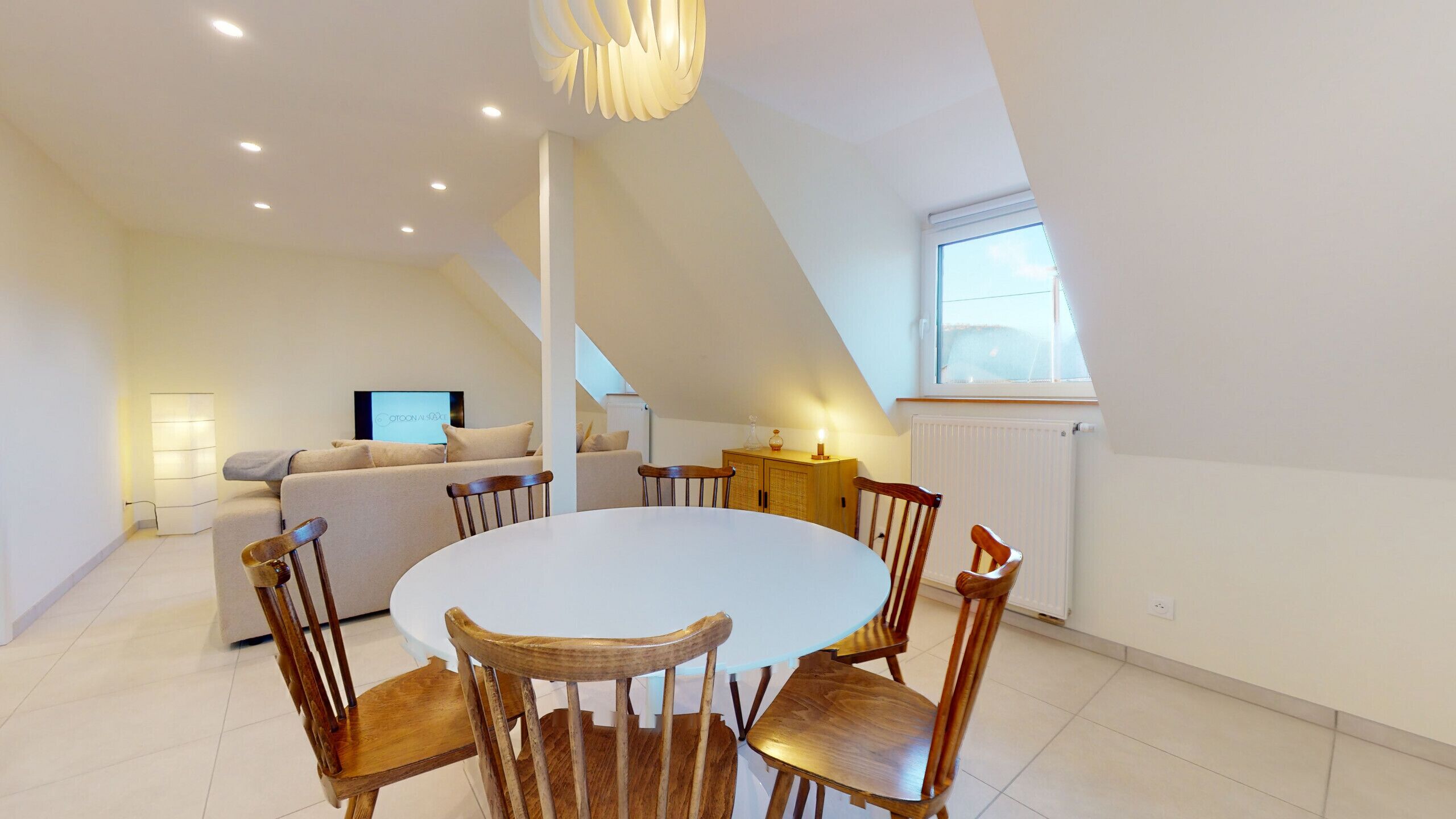 Een modern loft appartement met een eethoek, een woonkamer en een televisie.