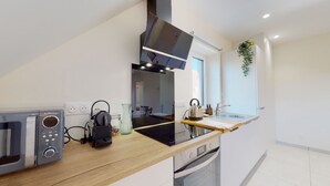 Een moderne keuken met een ingebouwde magnetron, waterkoker en oven.